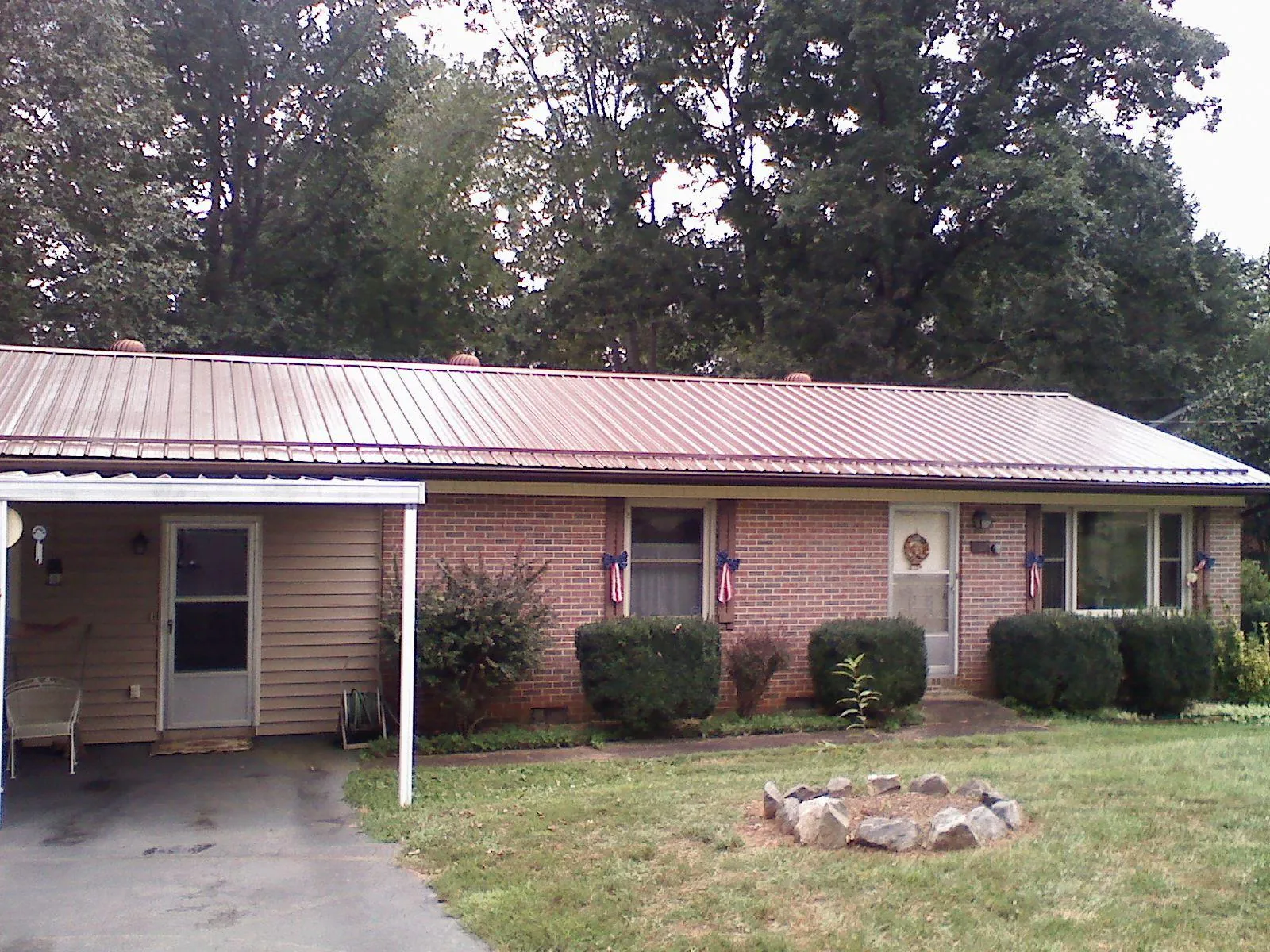 Bronze metal roof and carport on a brick ranch home — Roof Repair work by our crew in Langlois